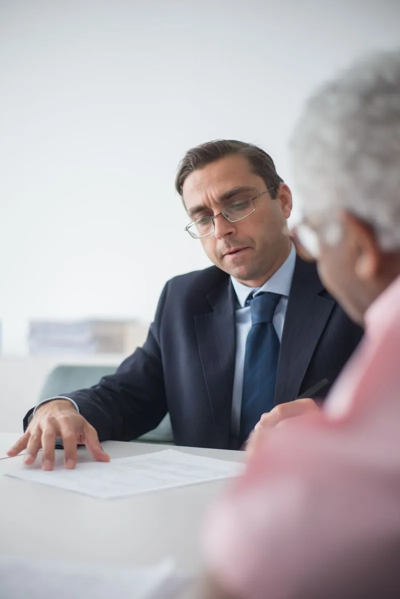 Two professionals reviewing evidence documents together in a bright office