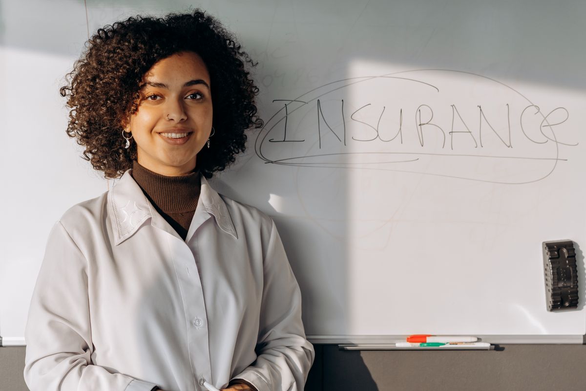 Insurance professionals reviewing documents and data on a laptop in a modern office
