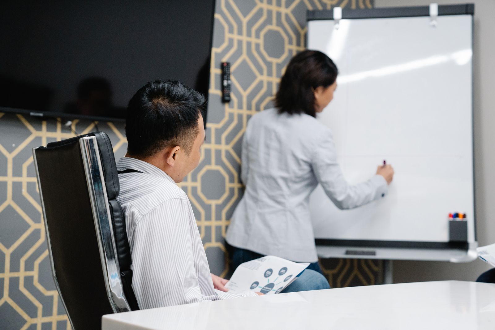 A Falx consultant reviewing a risk register with a client leadership team in a meeting room