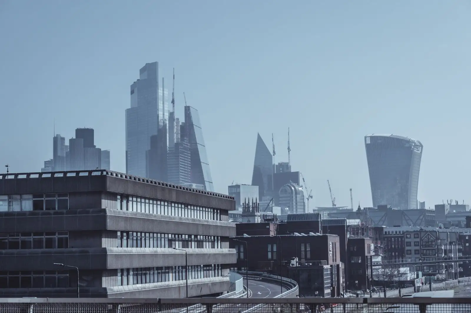 London financial district skyline with tall towers under a hazy blue sky