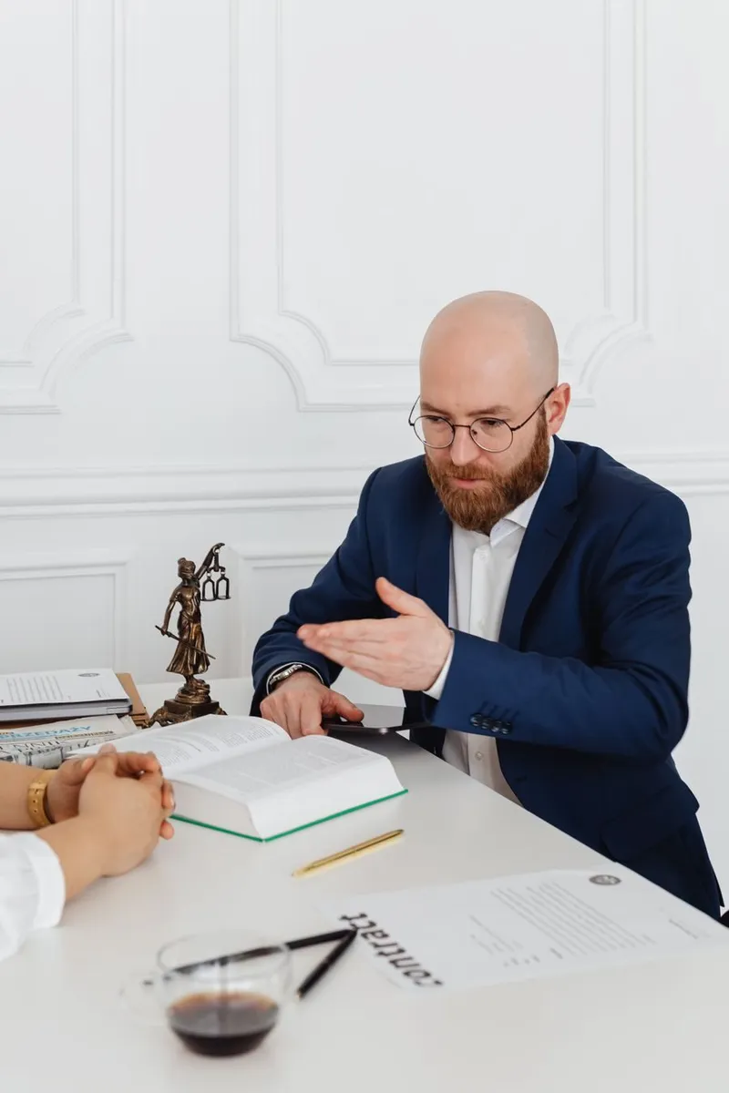 A consultant and client reviewing documents together across a bright office desk