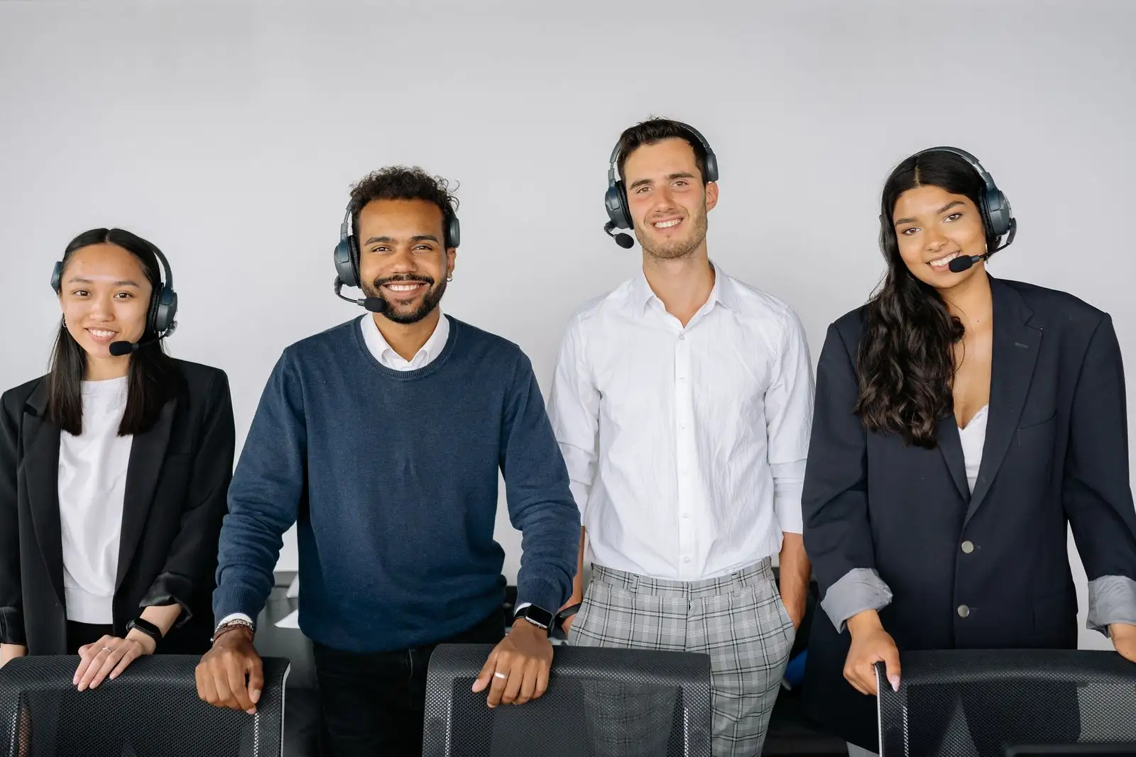 Support engineers wearing headsets working together at desks in a bright, open-plan office