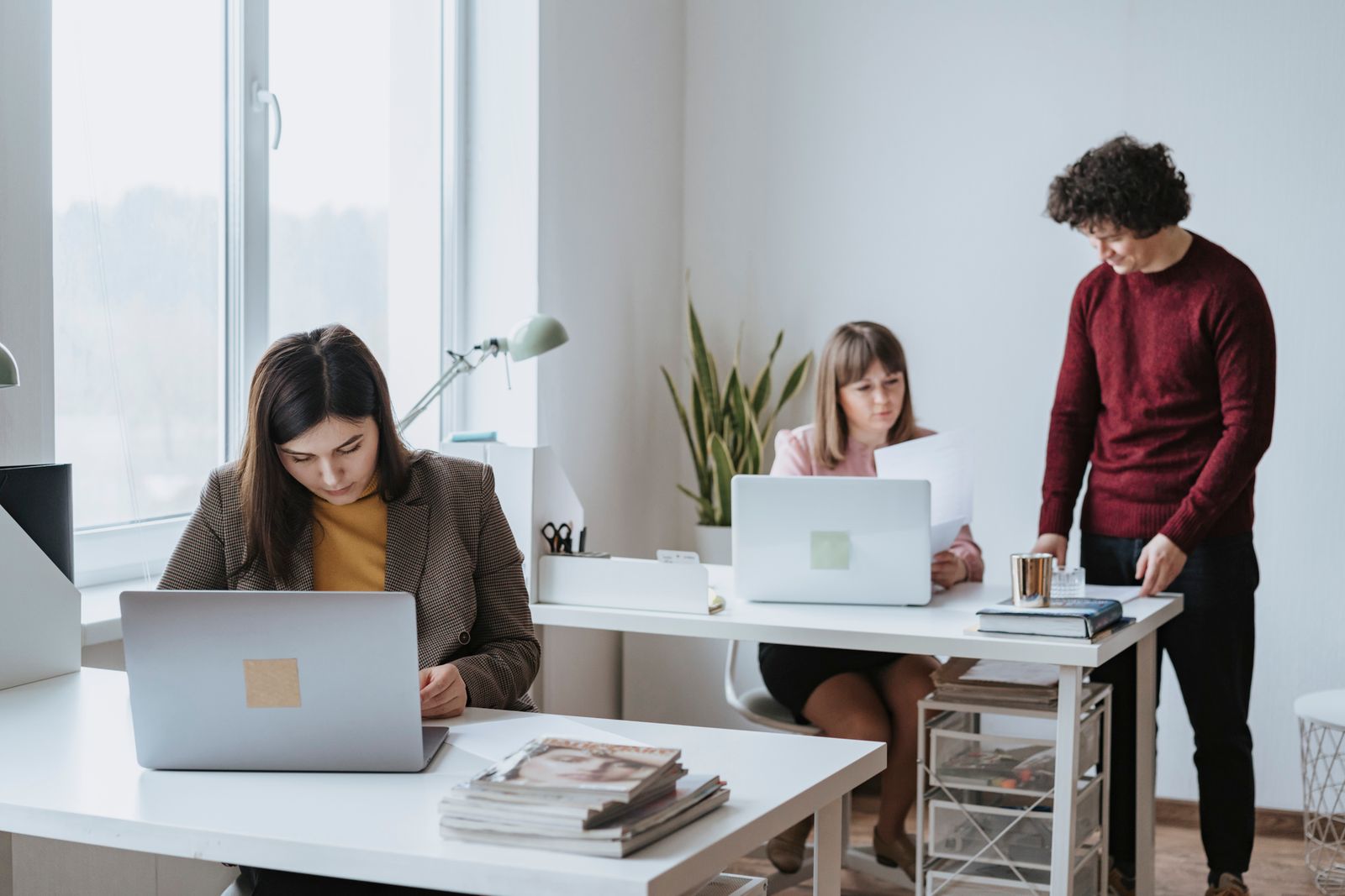Four colleagues working together on laptops in a bright modern office