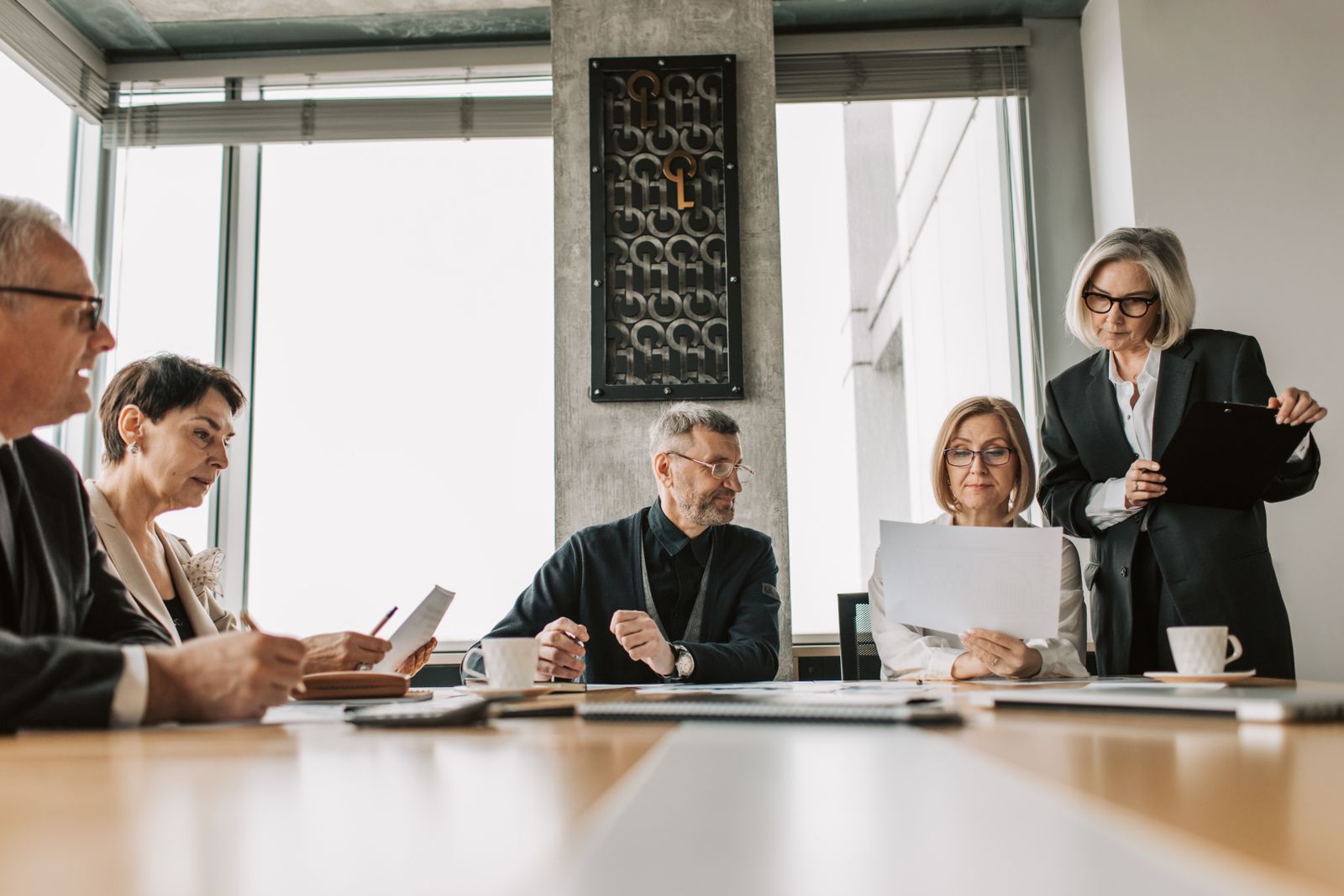Three colleagues discussing plans around a table in a bright modern office