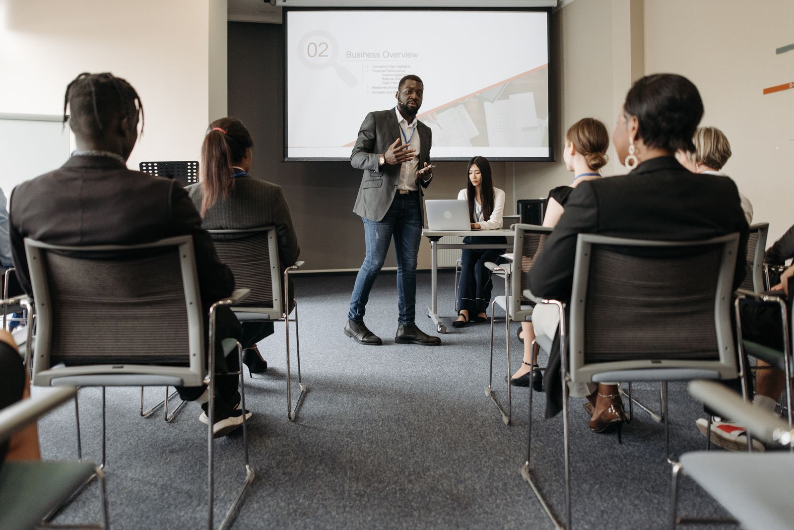 A trainer presenting to colleagues seated in a bright training room
