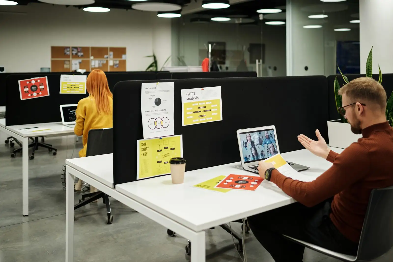 Colleagues joining a video meeting from laptops in a bright office